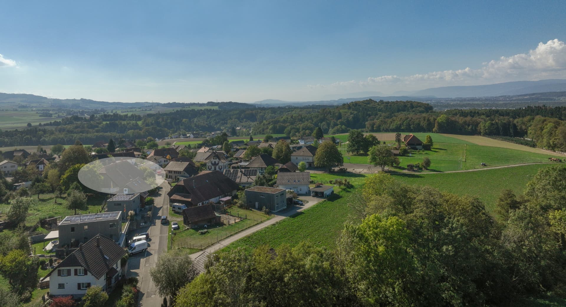 Luftaufnahme von Ammerzwil mit markiertem Wohnhaus und weiter Sicht über das Seeland